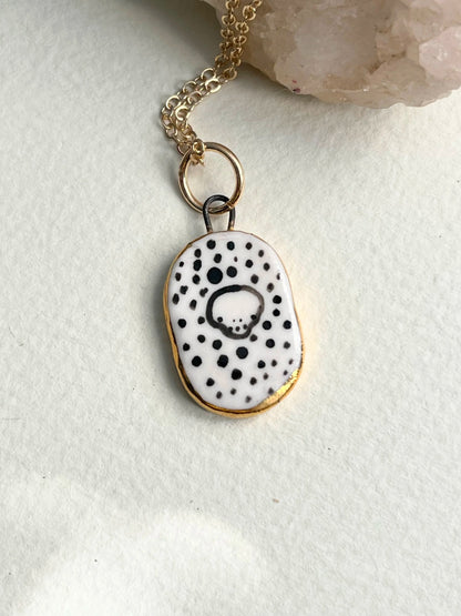 Porcelain Skull Pendant with gold rim by REBECCA EDELMANN