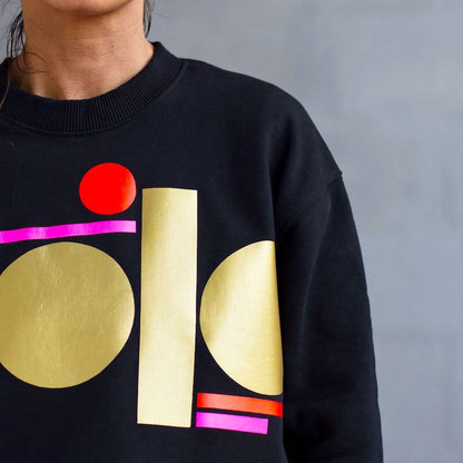 neon pink and gold tag on black sweatshirt - women’s fit by Touch Press Studio