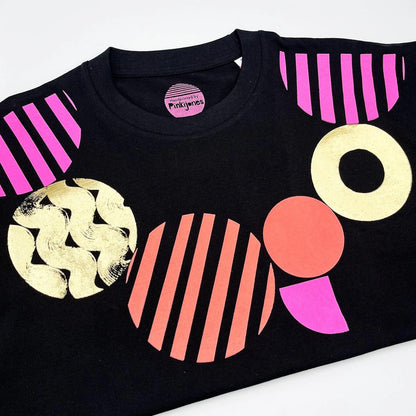Black t-shirt with colorful geometric shapes on a white background