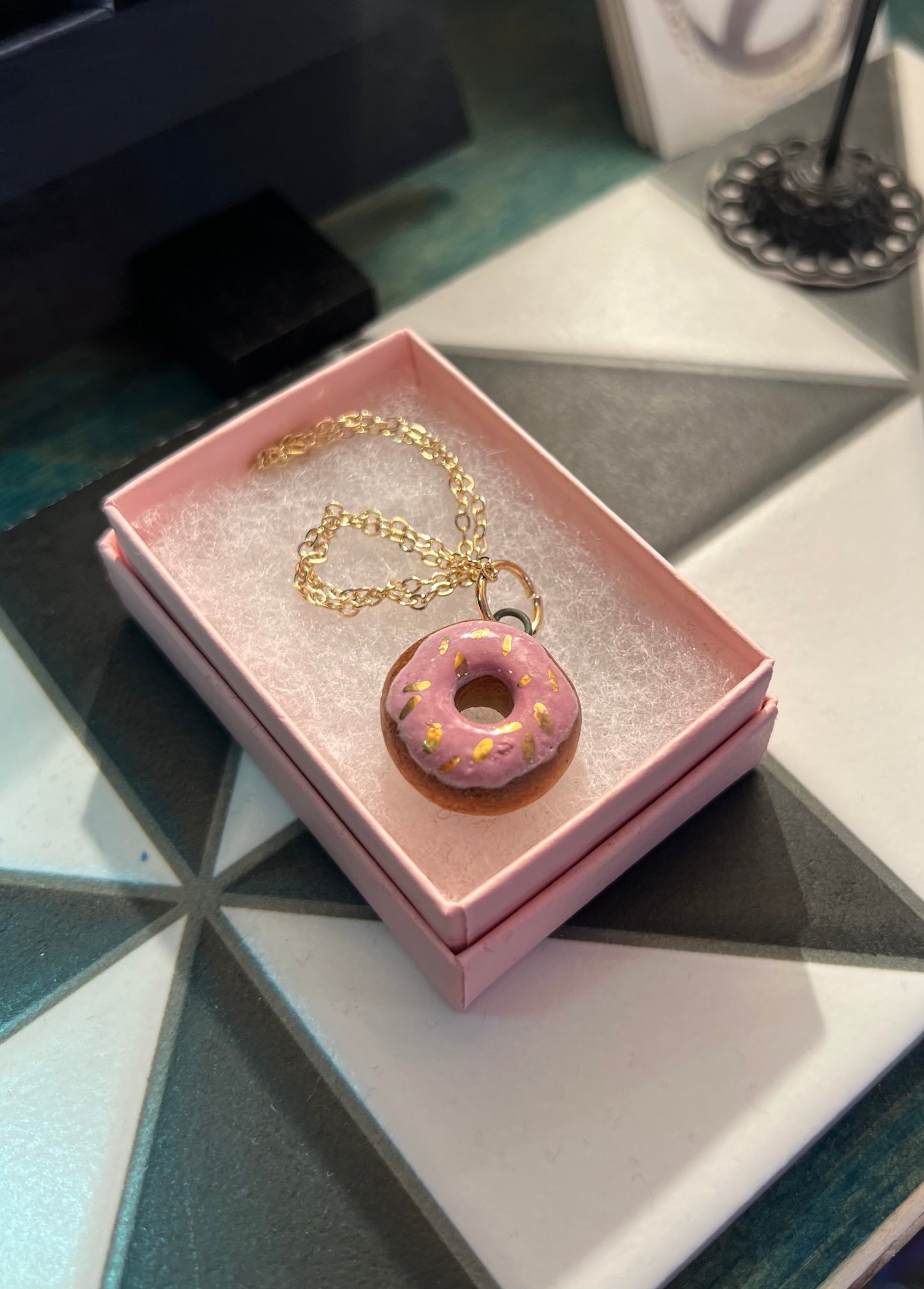 Porcelain doughnut pendant with gold rim by REBECCA EDELMANN