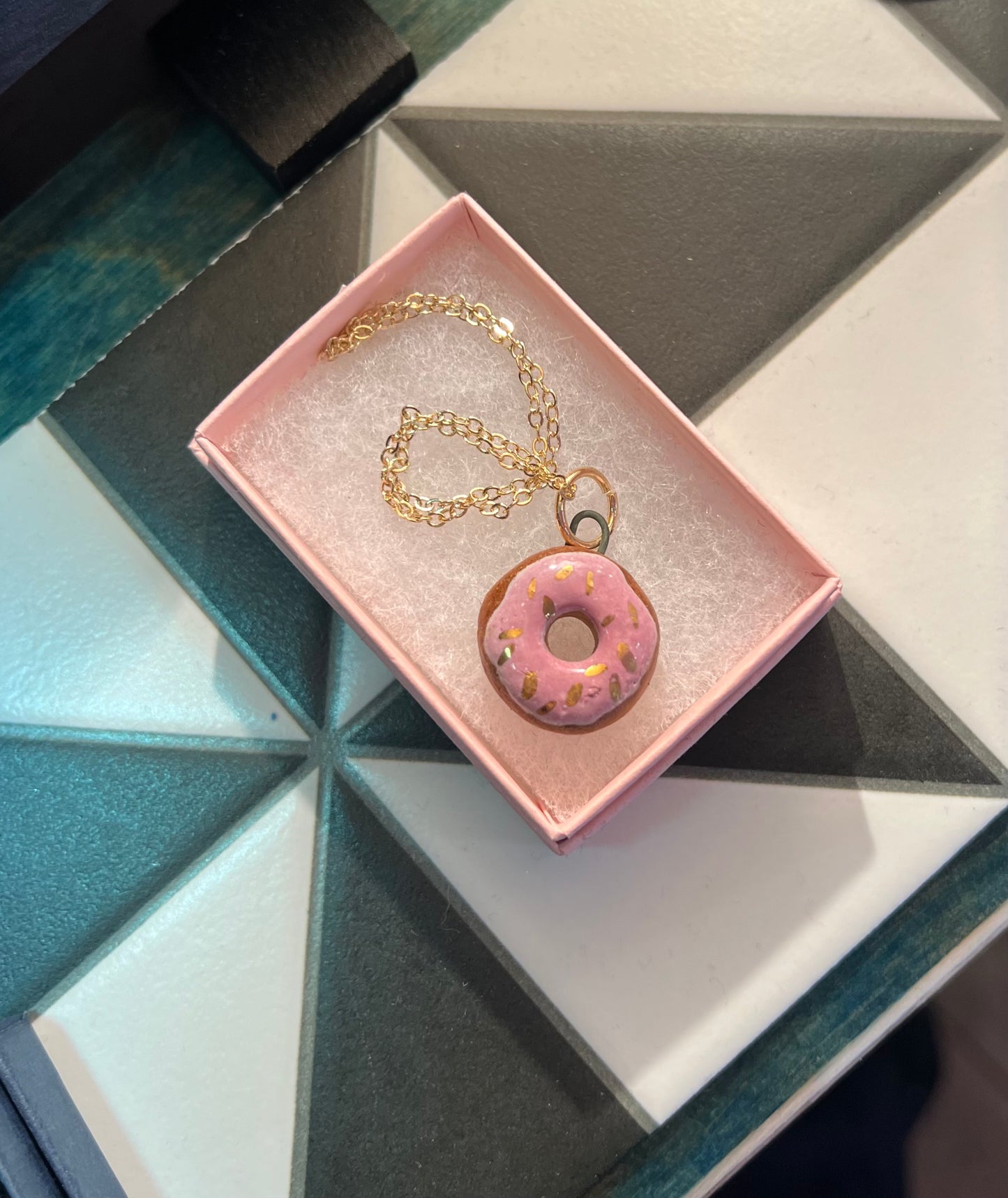 Porcelain doughnut pendant with gold rim by REBECCA EDELMANN