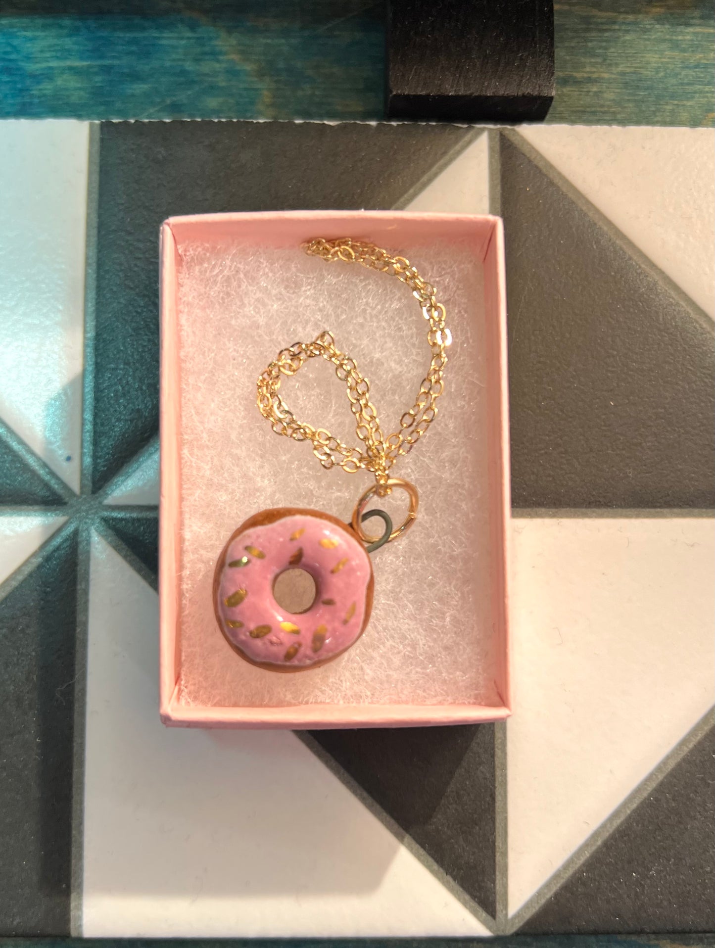 Porcelain doughnut pendant with gold rim by REBECCA EDELMANN